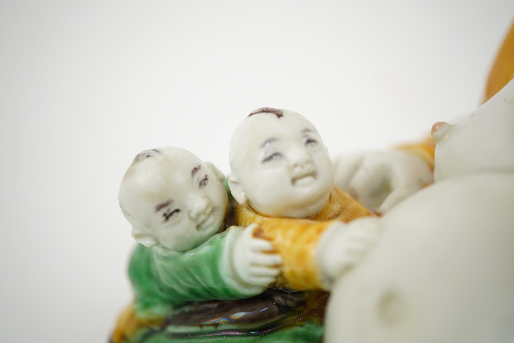 A Chinese sancai glazed biscuit group of Budai and three boys, 19th century